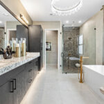 Modern bathroom with double sink vanity, freestanding bathtub, glass shower, large mirror, and contemporary fixtures in neutral tones.